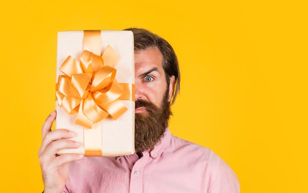 Hombre maduro con barba y peinado de moda celebrar aniversario de caja de regalo