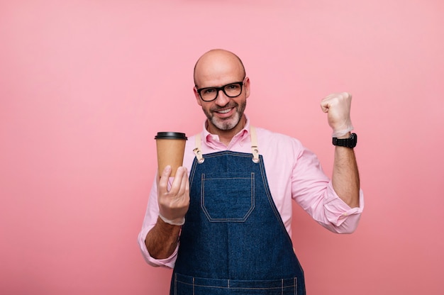 Hombre maduro Calvo eufórico de felicidad con café en taza de cartón reciclable