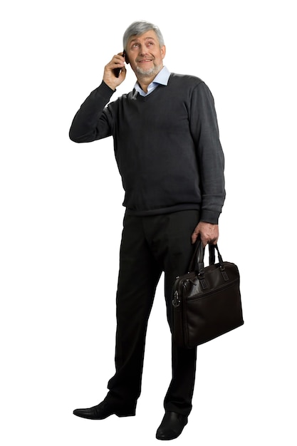 Hombre maduro hablando por teléfono. Hombre de pelo gris con teléfono mirando hacia arriba en blanco. Retrato de cuerpo entero.