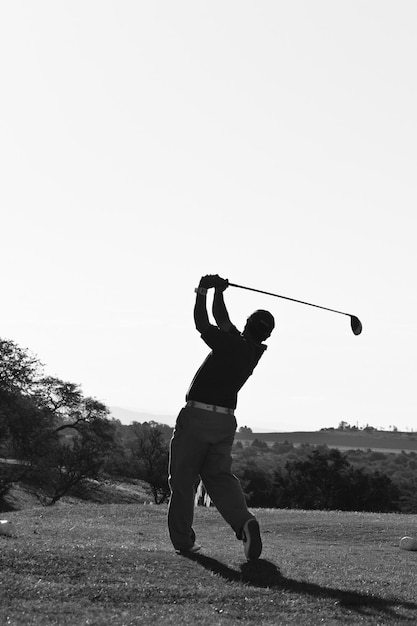 Foto hombre maduro jugando al golf contra un cielo despejado