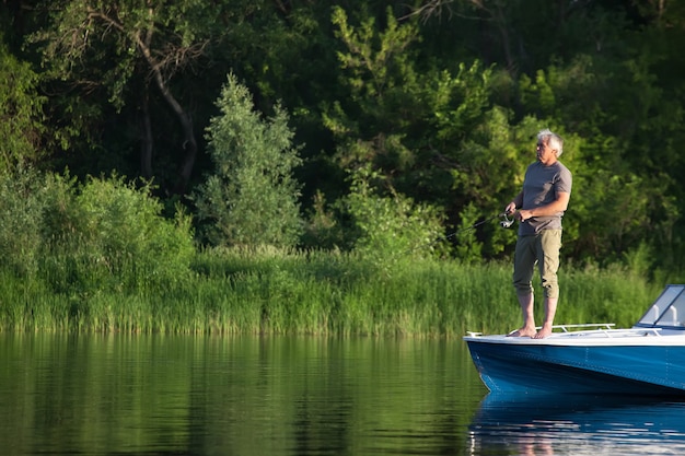 Hombre maduro en una lancha a motor. Pesca.