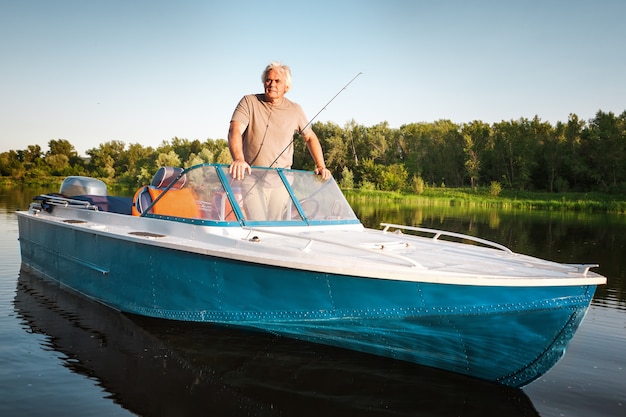 Hombre maduro en una lancha a motor. Pesca.