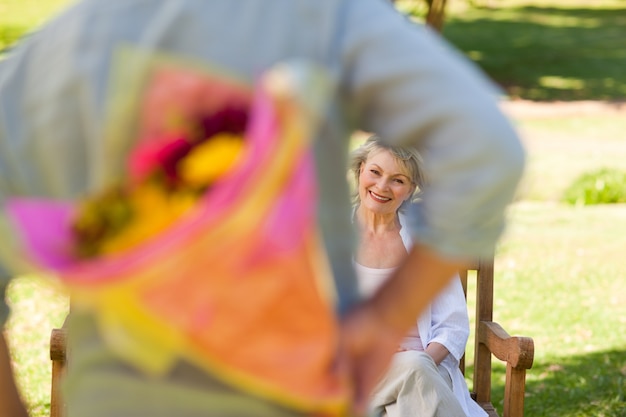 Hombre maduro ofreciendo flores a su esposa