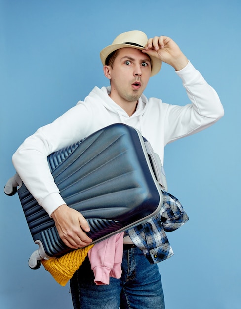 Un hombre con una maleta se apresura al avión, las cosas se caen del equipaje