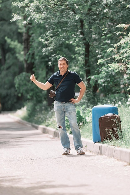 Hombre con maletas votos en el camino