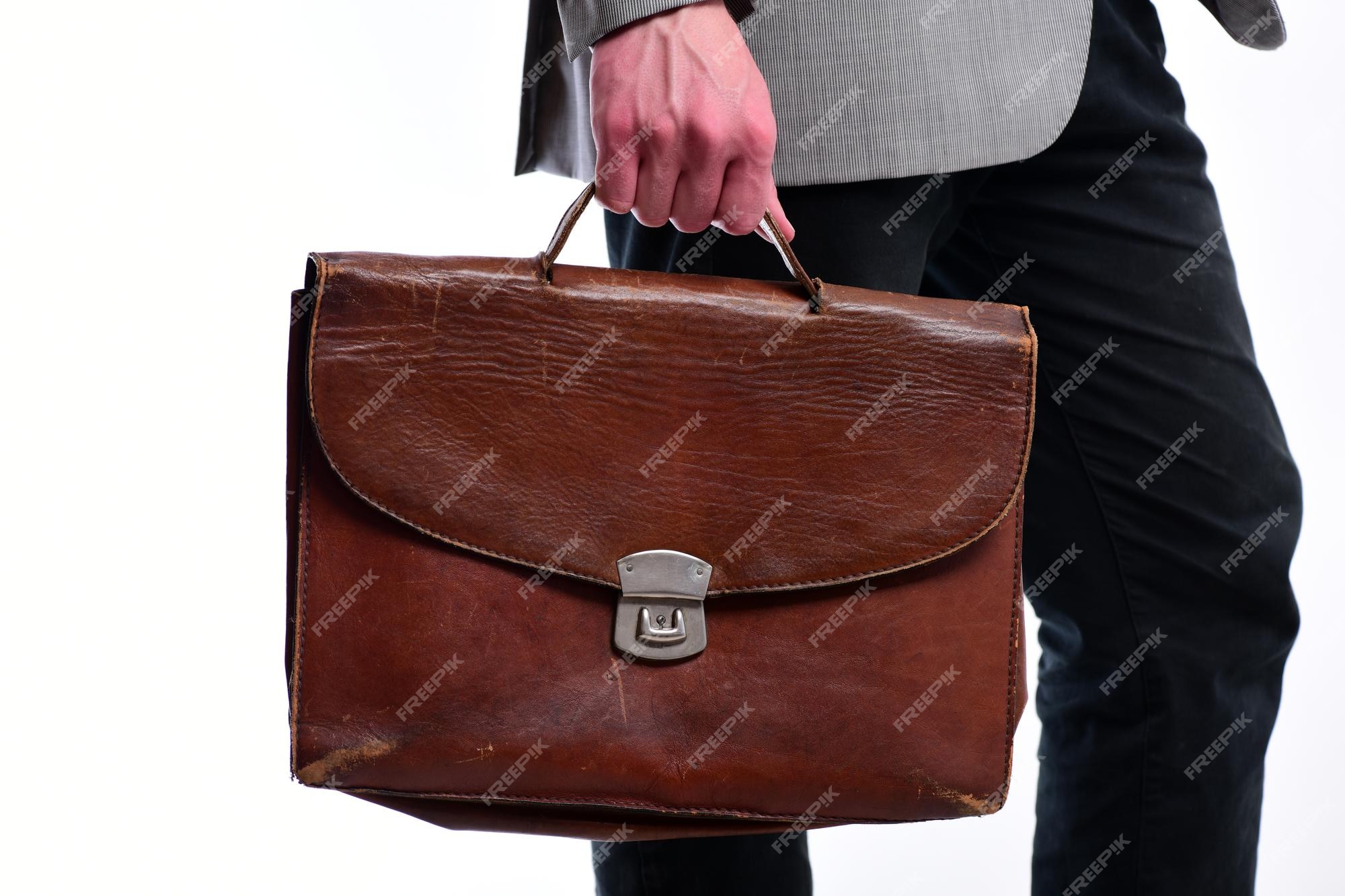 Hombre con maletín aislado sobre fondo blanco. estilo académico y de negocio. la mano sostiene una bolsa de cuero marrón. estilo de trabajo y moda | Foto