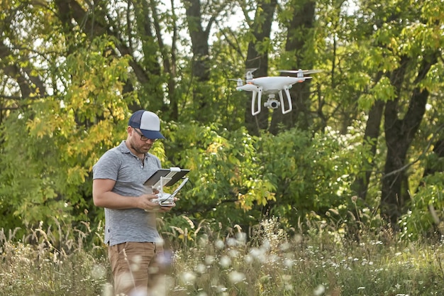 Hombre maneja quadrocopters Control remoto para el dron en manos de hombres Vehículo aéreo no tripulado