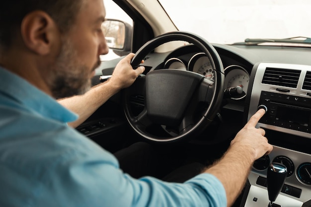 Hombre manejando auto y escuchando música