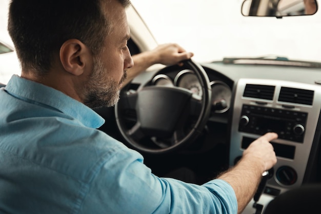 Hombre manejando auto y escuchando música