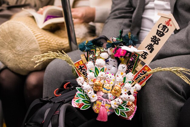 Foto hombre con maneki neko por mujer sentada en el tren