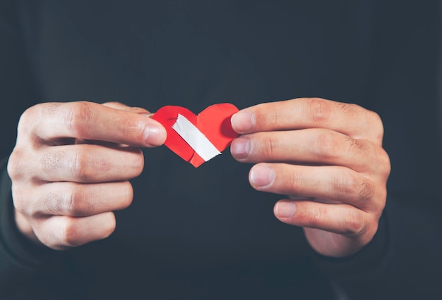 Hombre mano corazón roto