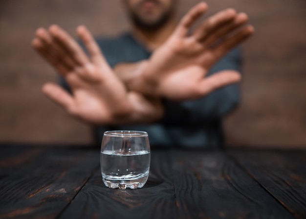 Hombre mano señal de stop vaso de vodka