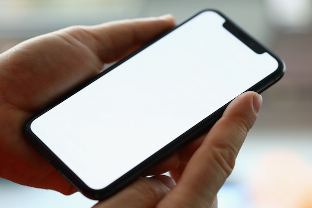Hombre mano sostenga smartphone moderno con scereen en blanco