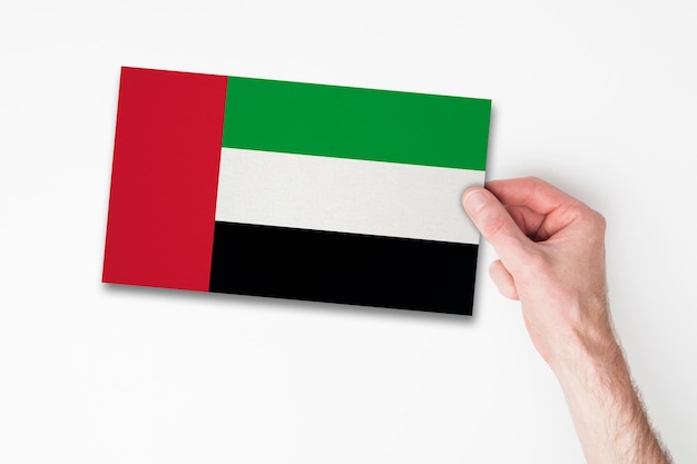 Hombre mano sosteniendo la bandera de los emiratos árabes unidos