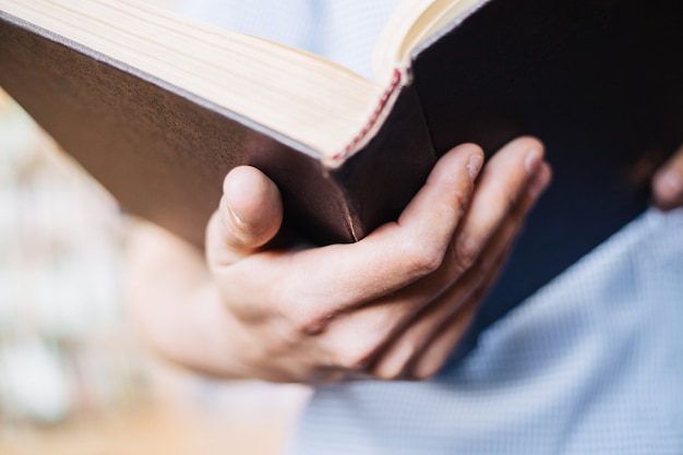 Hombre mano sostiene el libro abierto. vista del primer plano del libro.