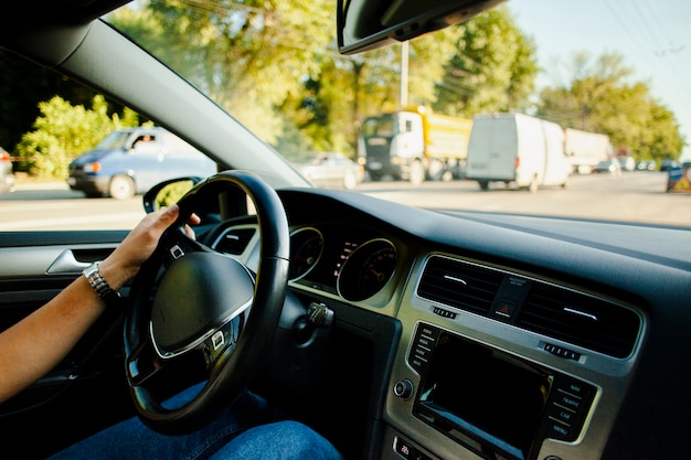 Hombre mano sujetando el coche de la rueda en el tráfico