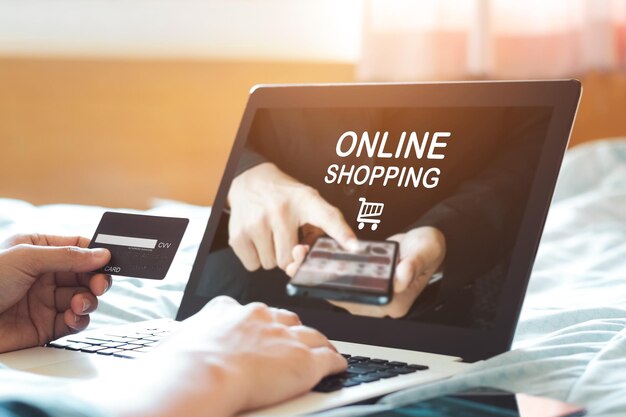 hombre con la mano usando portátil sitio web de maqueta y con tarjeta de crédito para comprar pago en línea en el hogar comercio electrónico y concepto de compras en línea
