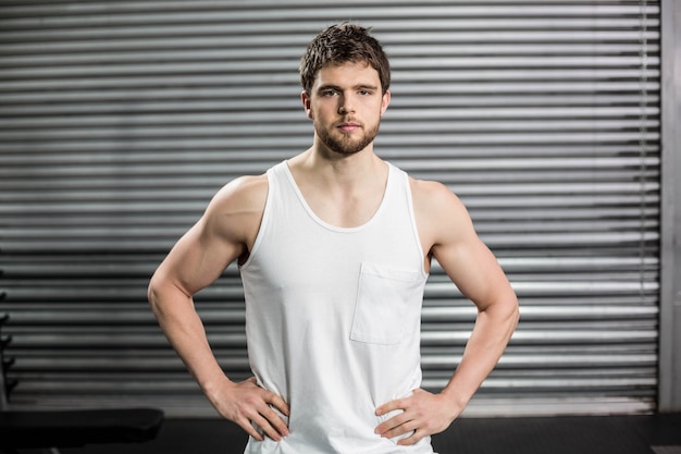 Hombre con las manos en las caderas en el gimnasio crossfit