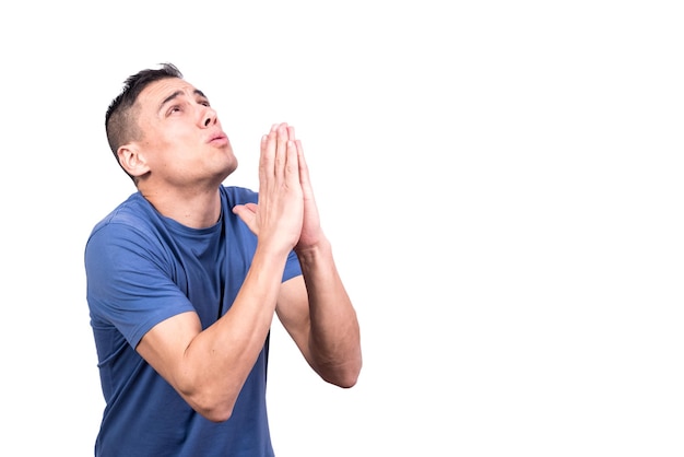 Hombre con las manos juntas rezando mirando hacia arriba