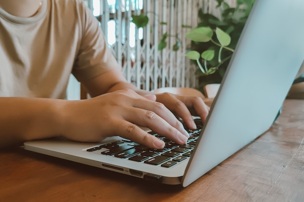 Hombre de las manos del primer que trabaja con una computadora portátil en café. Empresario. Lanza libre. Marketing online.