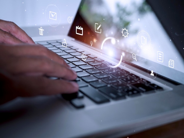 Foto hombre de manos que usa una computadora portátil con iconos de tecnología de comercio electrónico en la pantalla virtual concepto de marketing de redes sociales globales de negocios