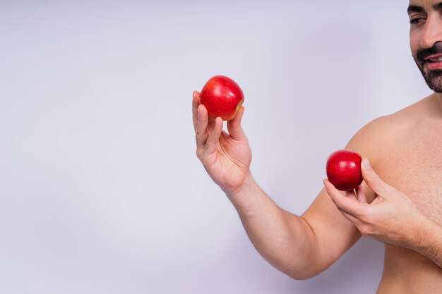 Hombre y manos sosteniendo una manzana en fondo blanco en el estudio para el bienestar de la salud o el apoyo inmunológico