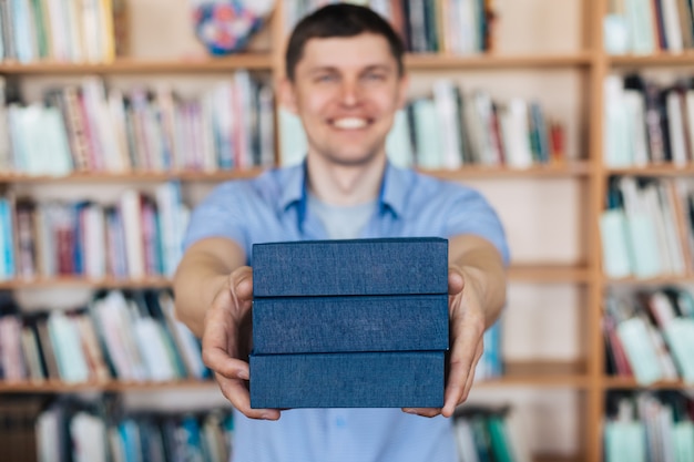 Hombre manos sosteniendo una pila de libros. El hombre sostiene una pila de libros.