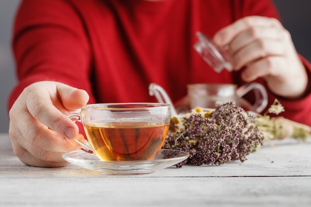 Foto hombre manos sosteniendo la taza con té de hierbas caliente. invierno y navidad, concepto de día de san valentín