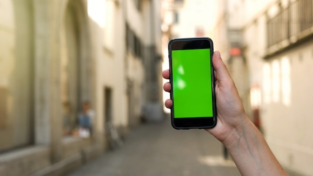 Hombre manos sosteniendo teléfono inteligente con pantalla verde.