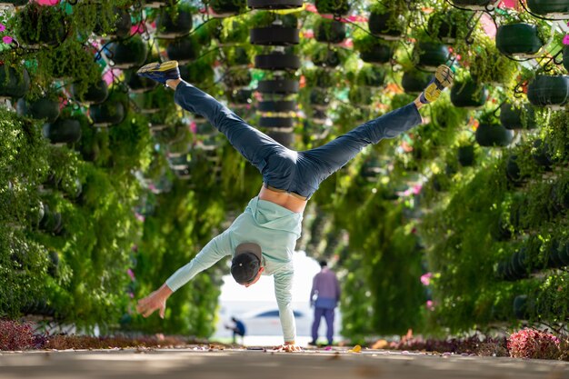 El hombre mantenga el equilibrio por un lado en el colorido arco floral y paraguas en la estación corniche doha ...