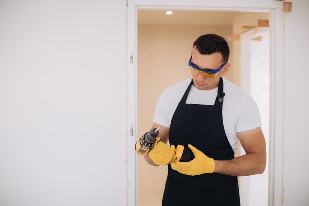 Hombre de mantenimiento arreglando puertas con instrumentos