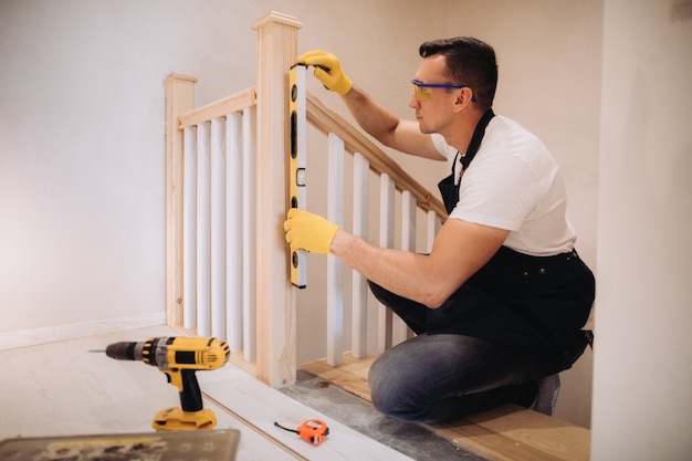 Hombre de mantenimiento trabajando con una herramienta de medición de nivel