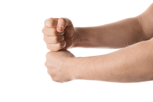 El hombre mantiene sus puños juntos, gesto con la mano. Aislado sobre fondo blanco.