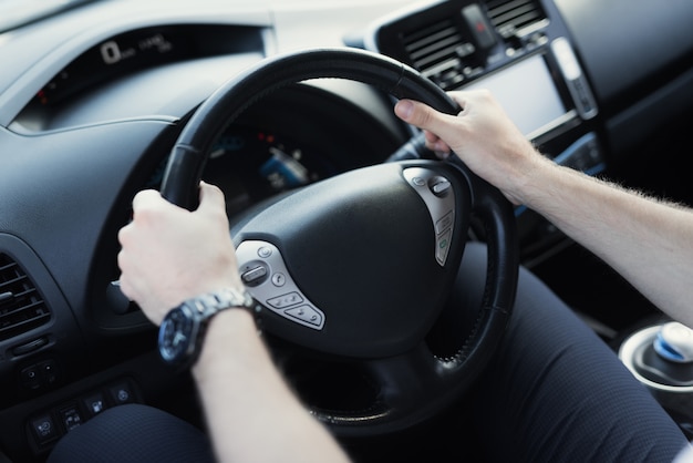 El hombre mantiene el volante del automóvil.