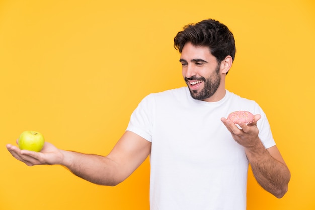 Hombre con manzana en una mano y dulce en la otra