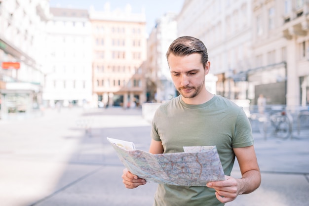 Hombre con un mapa de la ciudad y una mochila en la calle Europa.