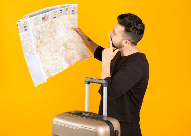 Hombre con un mapa y una maleta viajando concepto