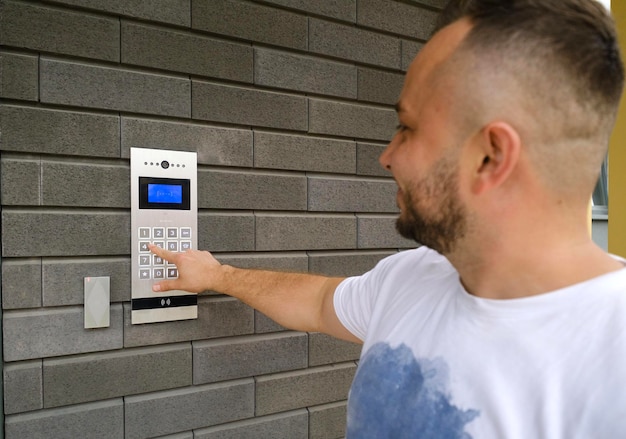 Foto el hombre marca el código del videoportero fuera del edificio para irse a casa.