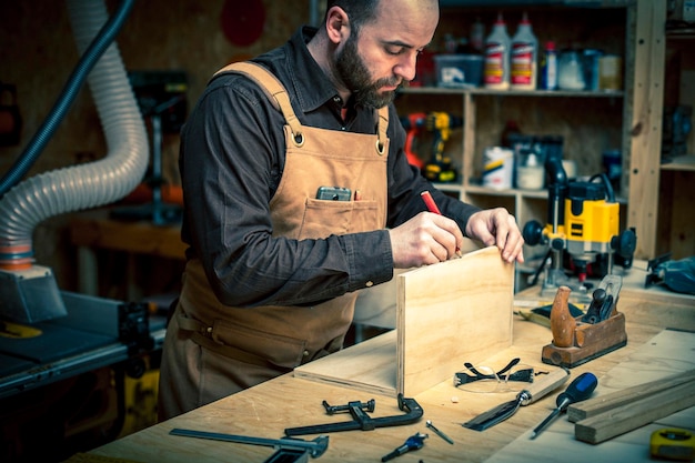 Hombre marcando en madera en el taller.