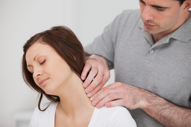 Foto hombre masajeando el cuello de su paciente