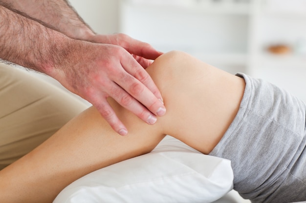 Hombre masajeando la rodilla de una mujer acostada