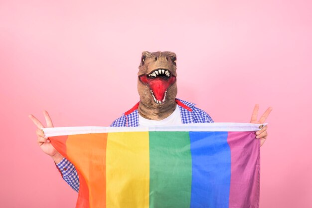 un hombre con una máscara con una bandera arco iris en la mano