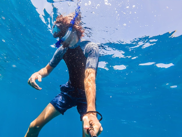 Hombre con máscara de buceo en agua clara