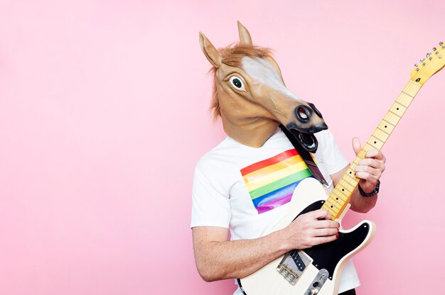 hombre con una máscara de caballo tocando la guitarra eléctrica.