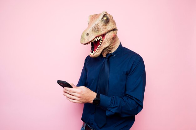 Hombre con máscara de dinosaurio con smartphone