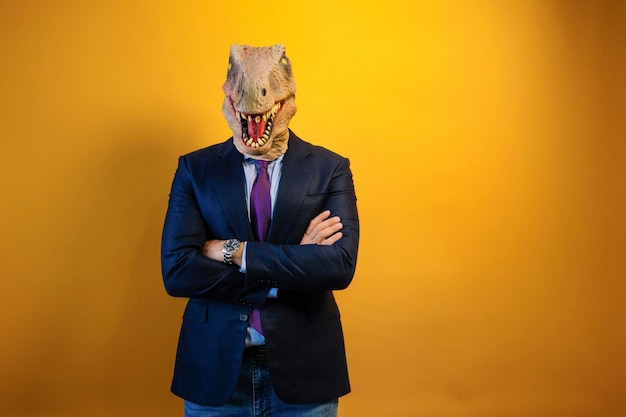 Un hombre con una máscara de dinosaurio y un traje sobre un fondo amarillo