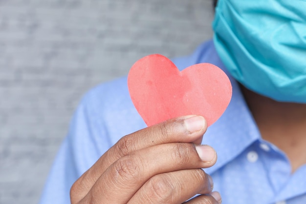 Foto un hombre con una máscara en forma de corazón para la esperanza y el amor