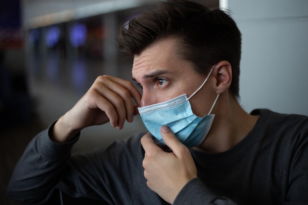 Hombre con una máscara médica tocando la máscara