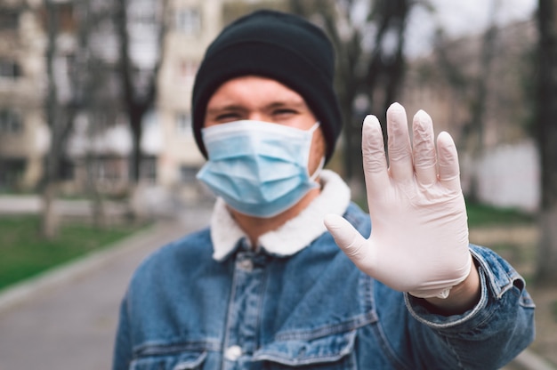 Hombre con máscara protectora y guantes al aire libre