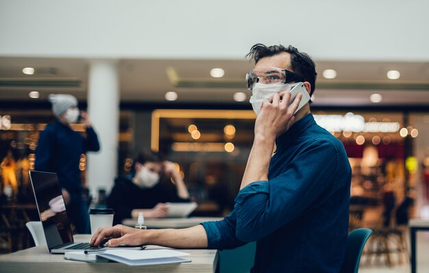 Hombre con máscara protectora hablando por su teléfono inteligente. foto con espacio de copia